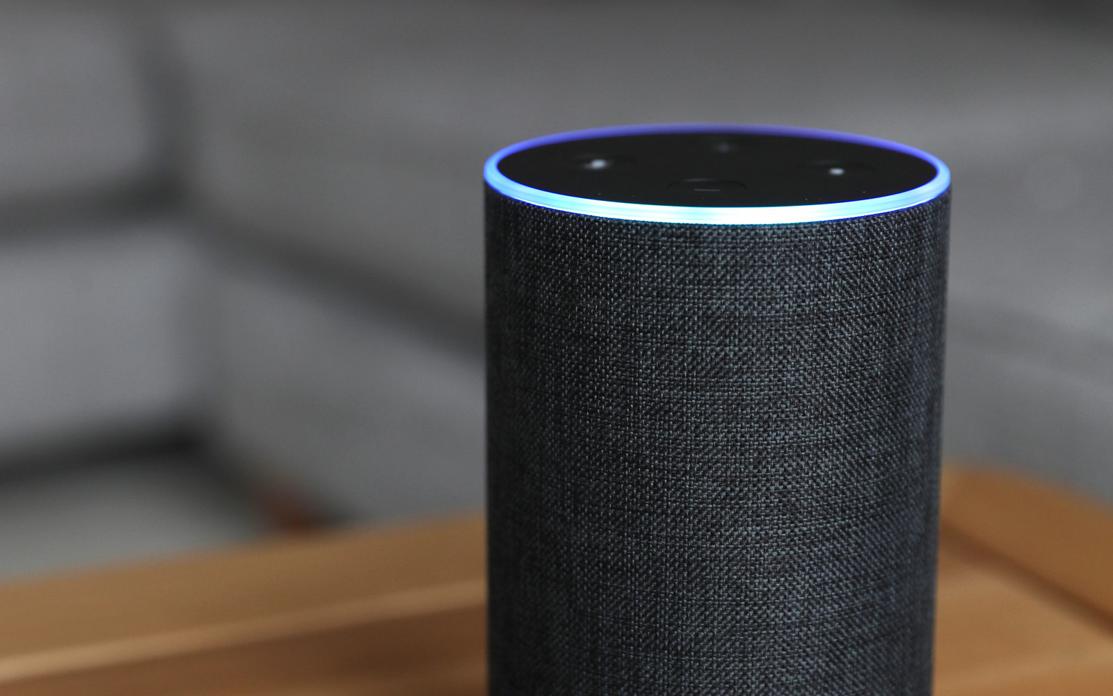 An Amazon Alexa turned on with a blue light around the rim.