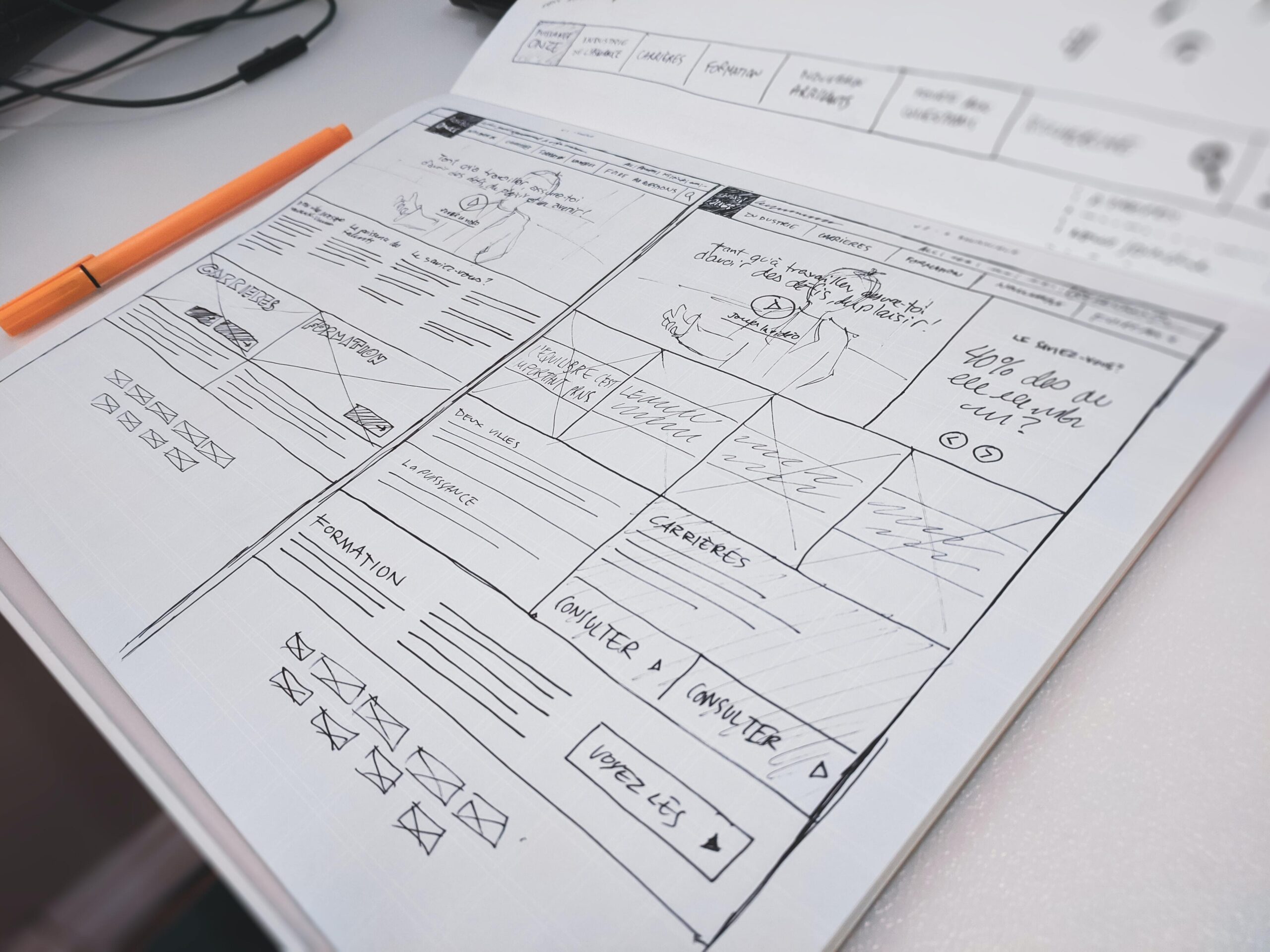 An open notebook with hand-drawn wireframes.