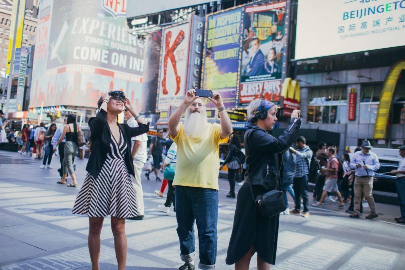 People standing in Times Square, New York using phones and VCR glasses